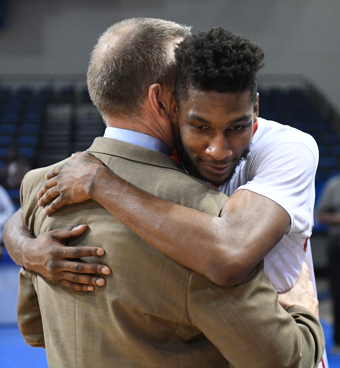 Basketball player his hugging coach
